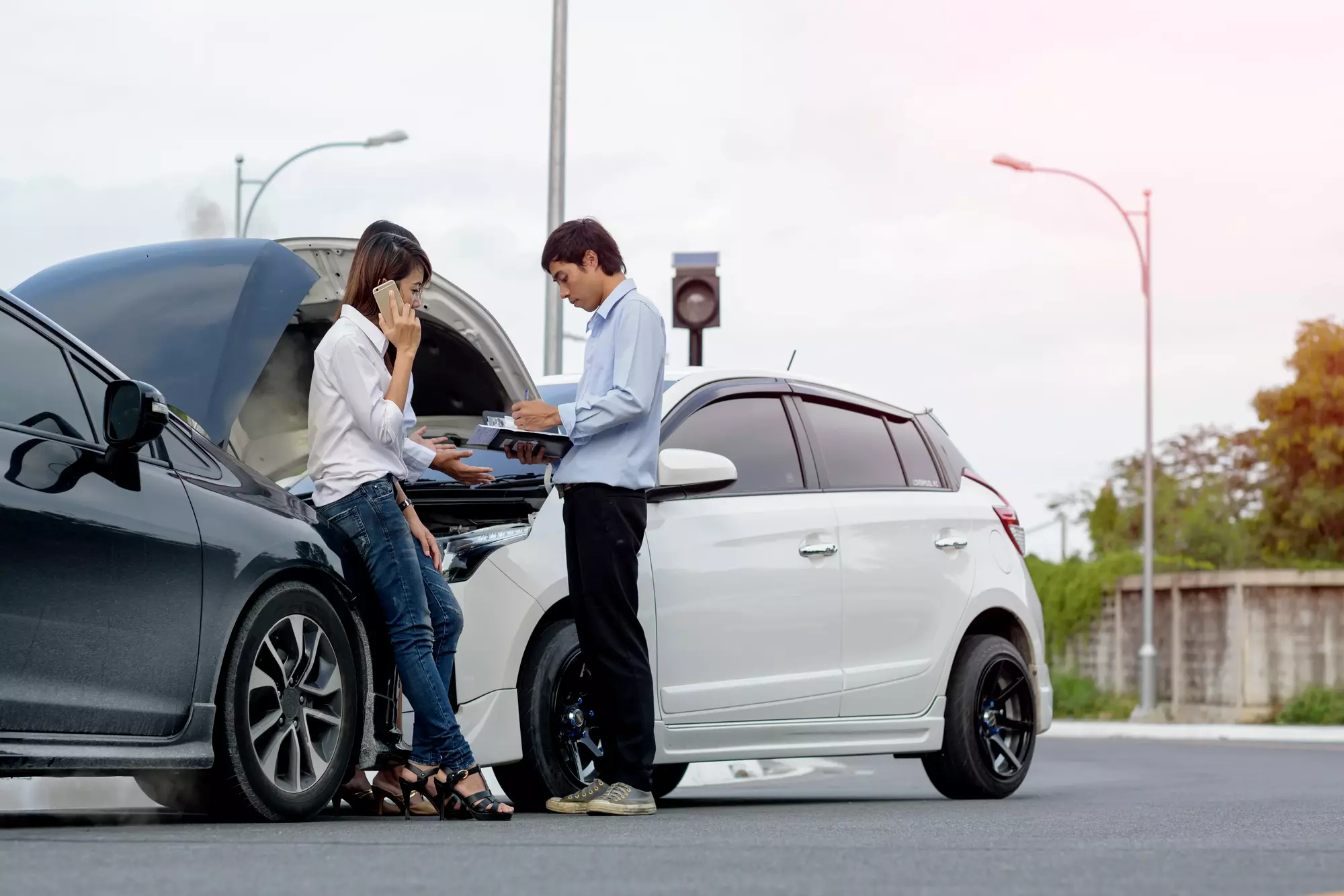 Two cars in an accident and the drivers are exchanging information.
