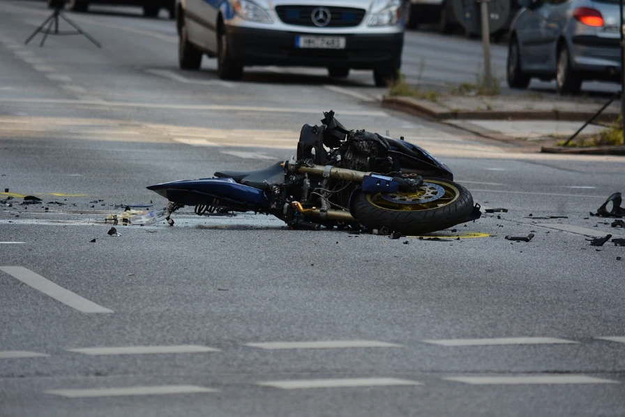A wrecked motorcycle in the road.