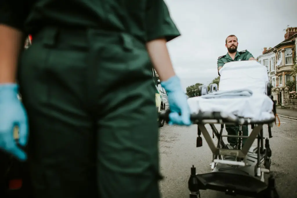 EMTs walking a stretcher to someone injured.