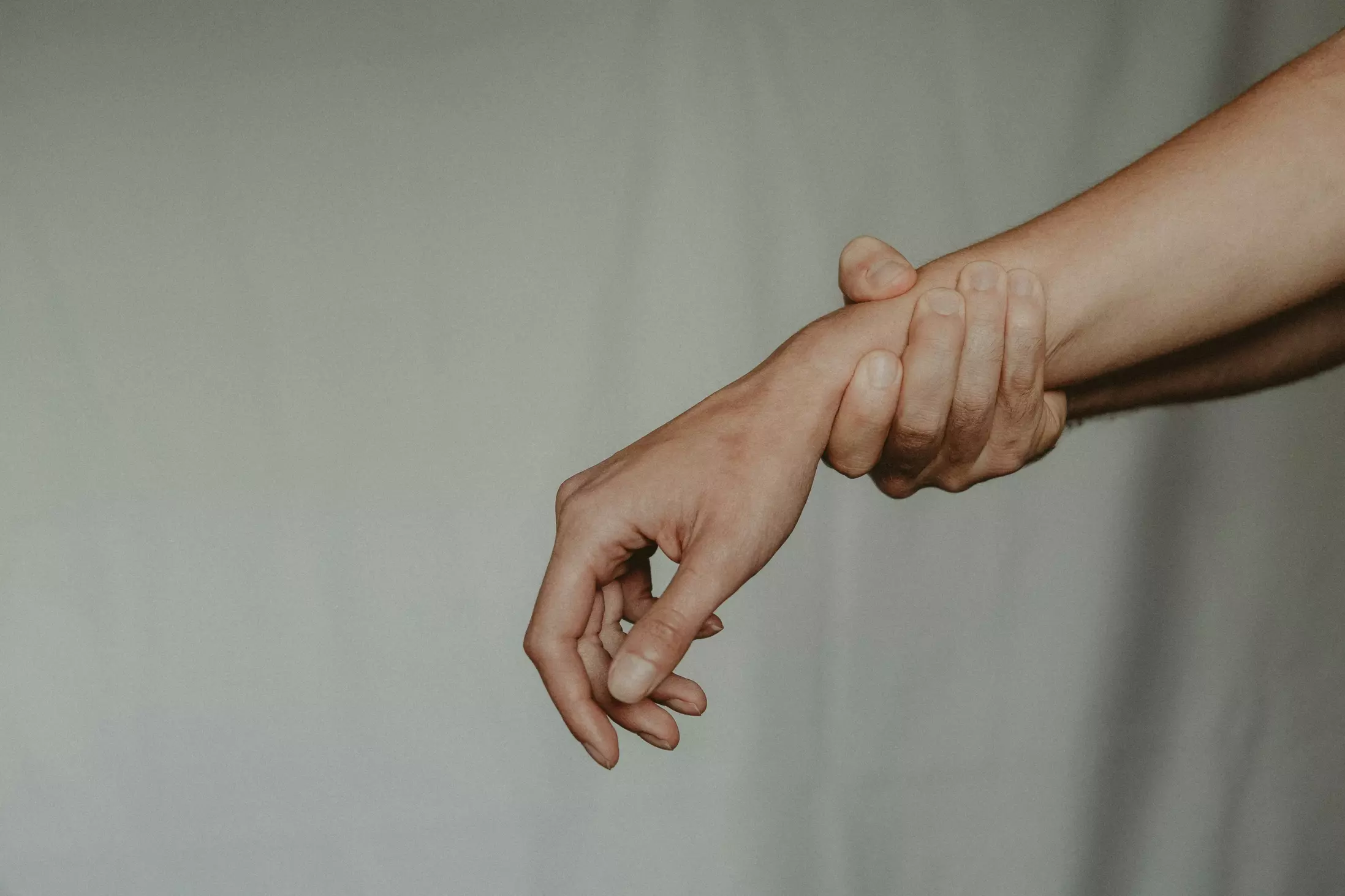 An arm being grasped at the wrist.