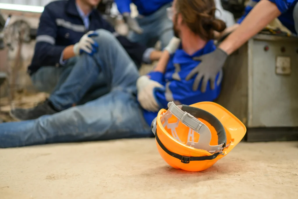 Injured man on ground holding his arm.