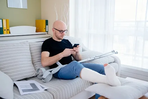 Man lying in bed with an injured leg.