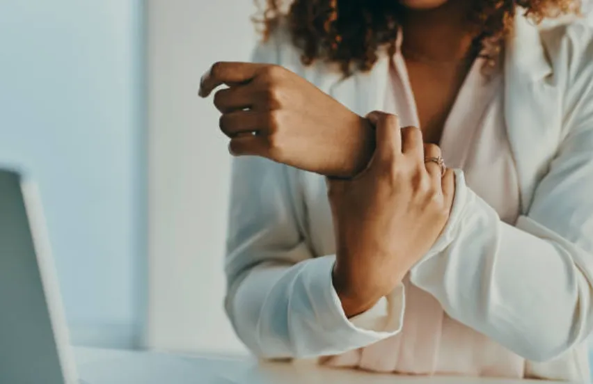 A woman holding her wrist.