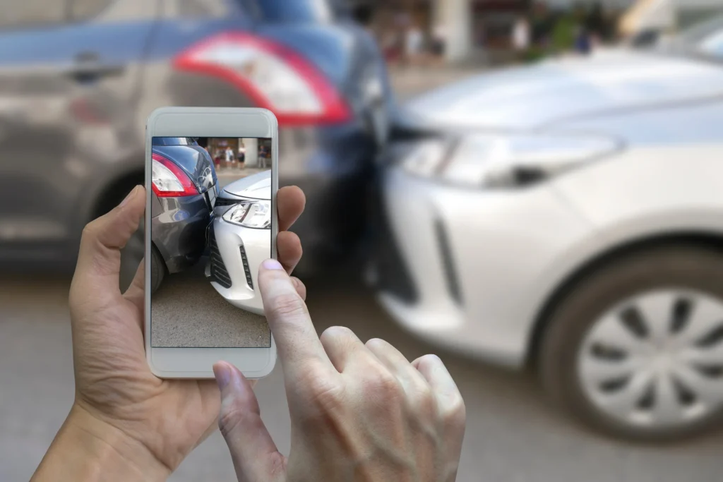 Someone taking a picture on their phone of a rear-end collision.